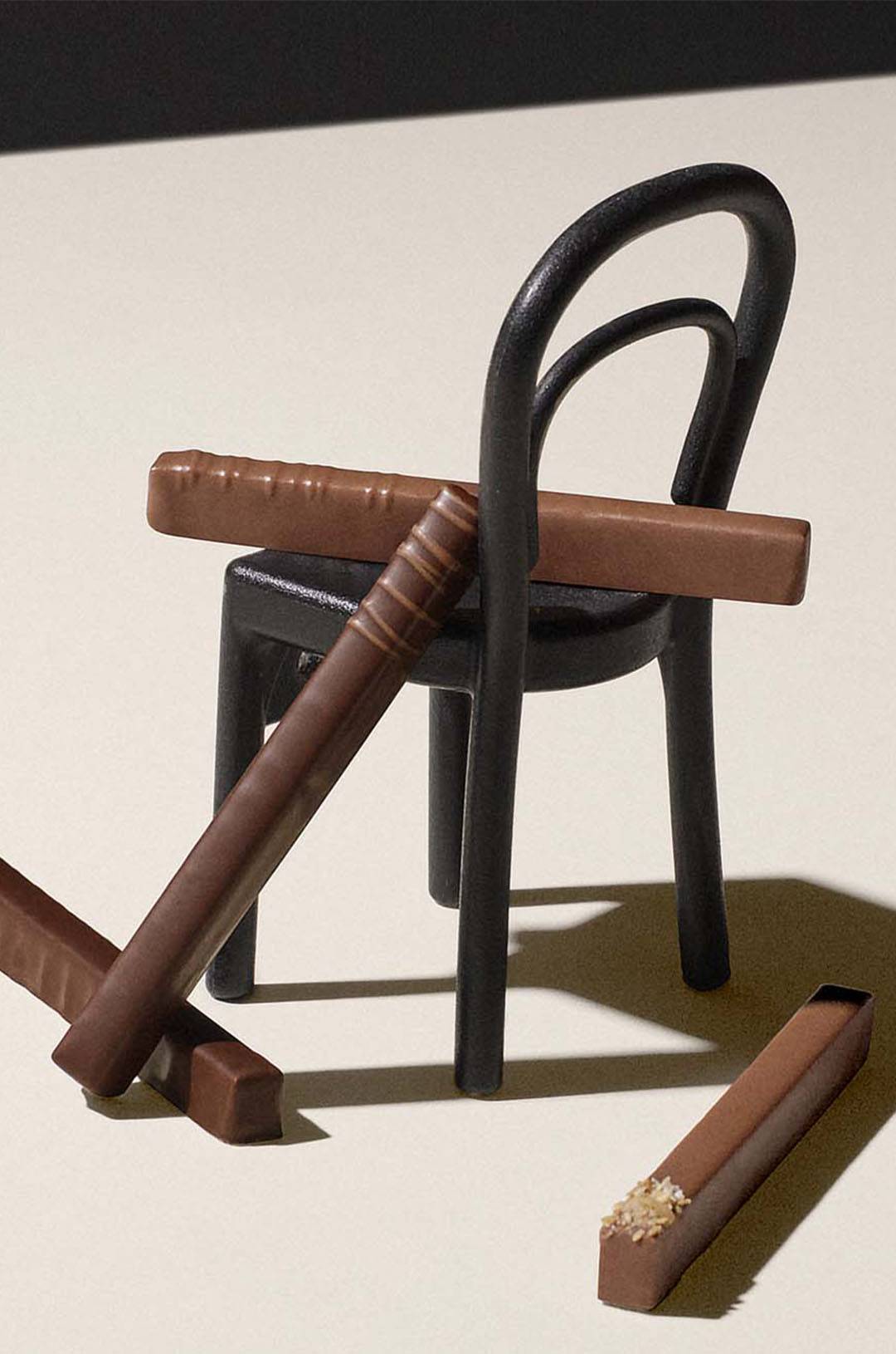 Bâtons de chocolat traversant le dossier d'une chaise noire