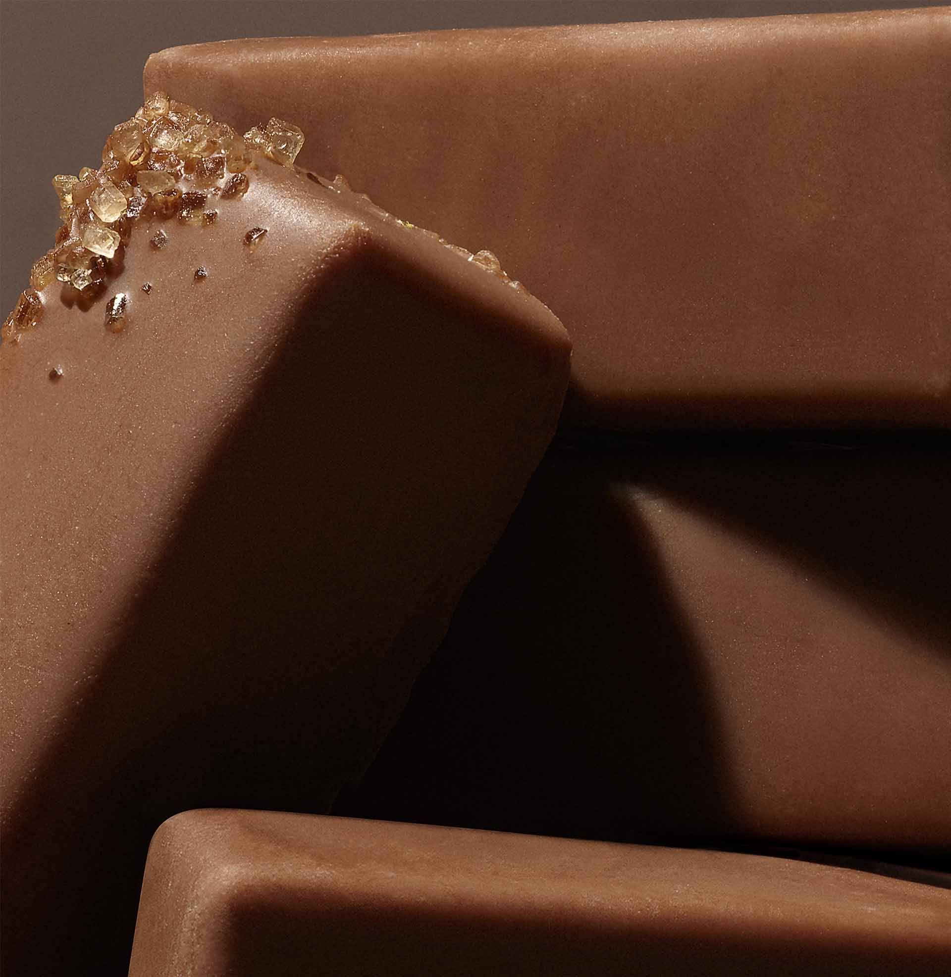 Barre de chocolat avec cristaux de sucre dorés sur surface lisse